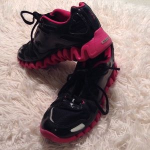 Pink and black reebok zig tech athletic shoes.